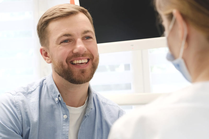 a dental implant consultation patient smiling about dental implant surgery options.